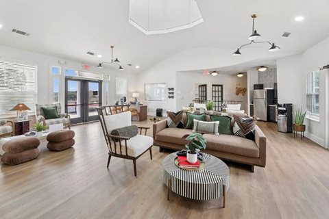 A living room with a brown sofa, a coffee table, and a dining table.